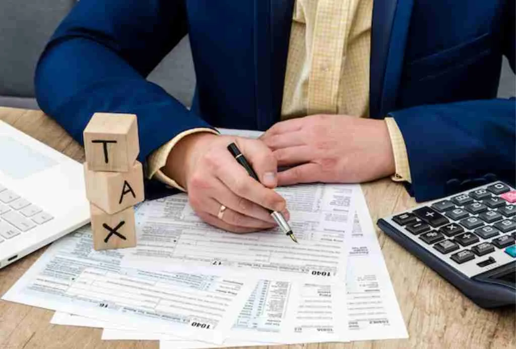 Professional reviewing tax forms with a pen and calculator.