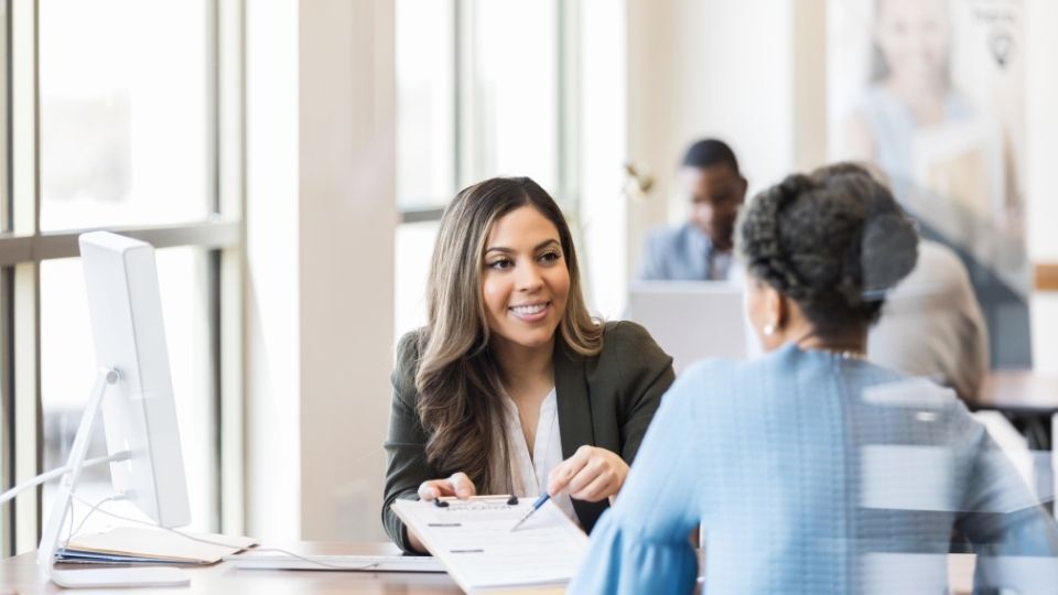 In the image a person can be seen guiding for business expansion loan application.