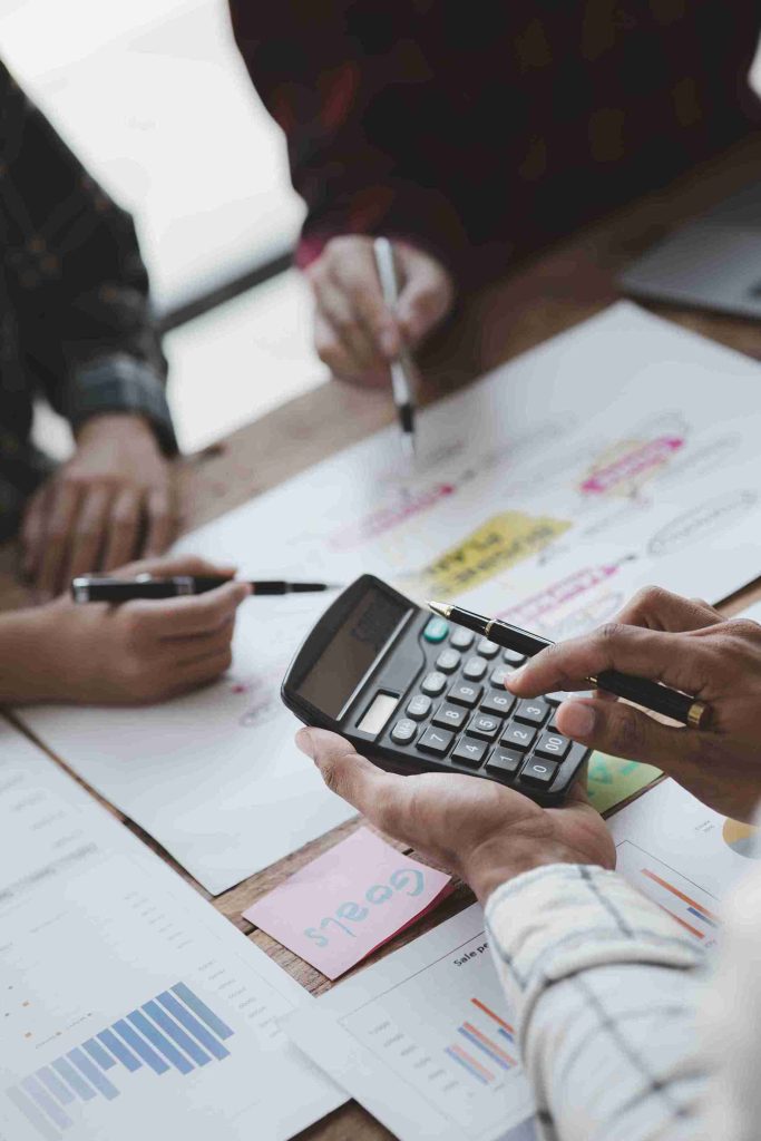 Business professionals collaborating on a spreadsheet at a modern office workspace.