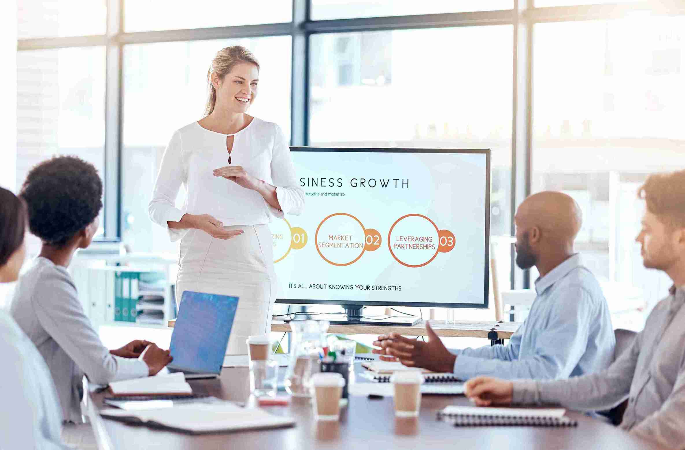 A woman presents to an engaged audience, sharing ideas and insights during a professional gathering.