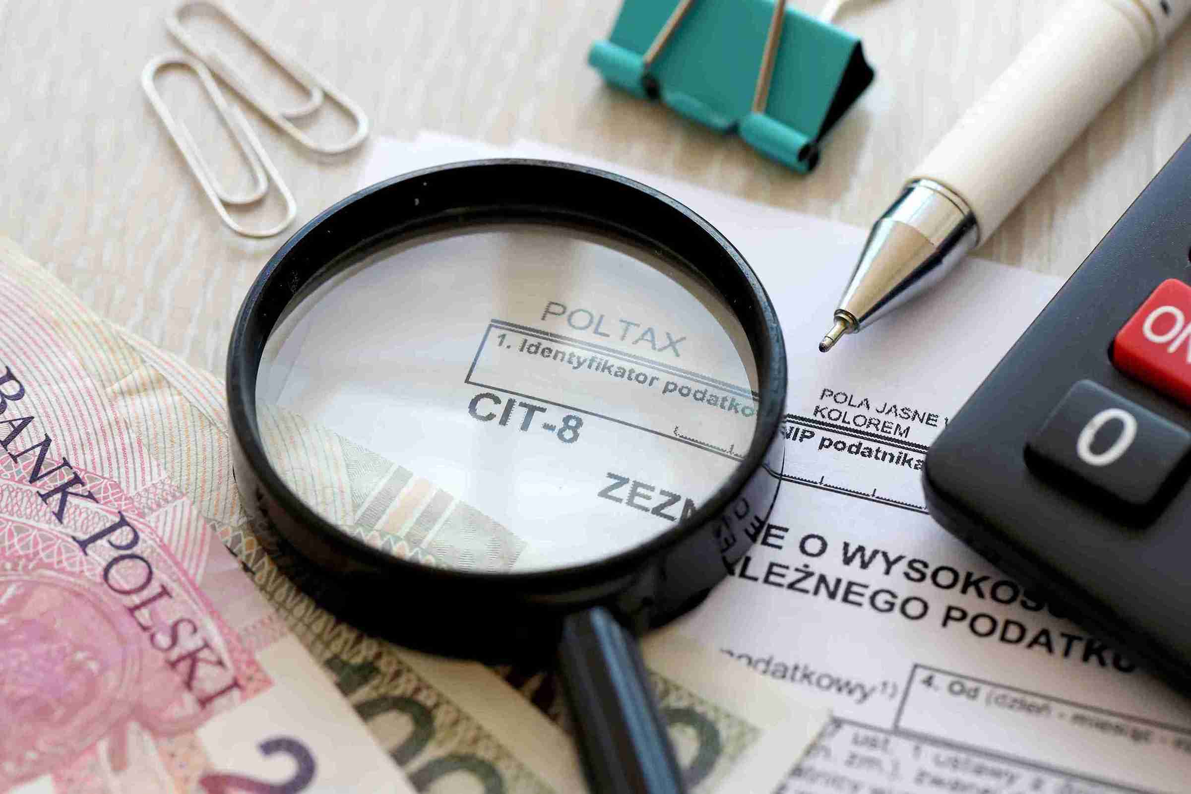 Tax return documents alongside stacks of cash, symbolizing financial planning and tax season.