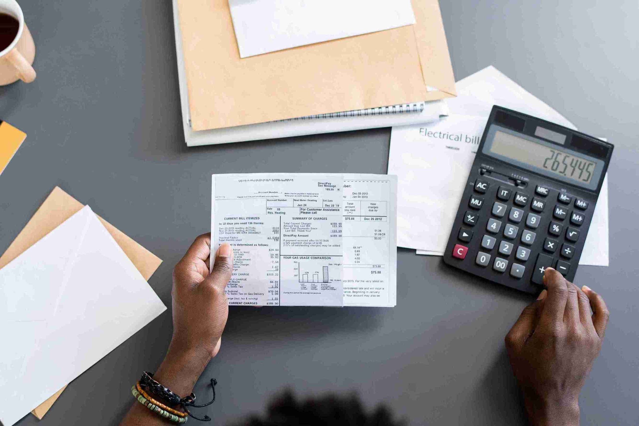 Image illustrating steps for preparing taxes, including forms, calculators, and a checklist on a desk.