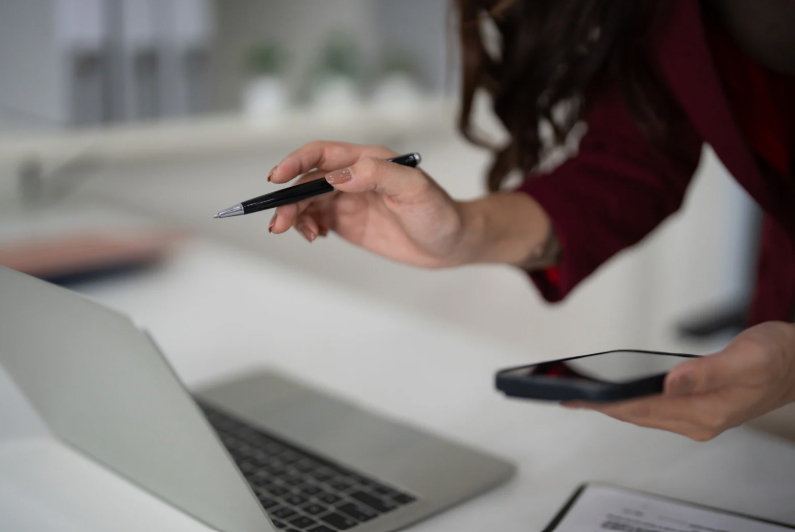 (A business owner using a laptop and smartphone to apply for VAT online.)apply for vat